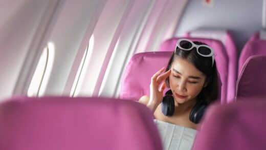 woman relaxing on airplane wearing headphones and 2026 03 17 01 26 37 utc